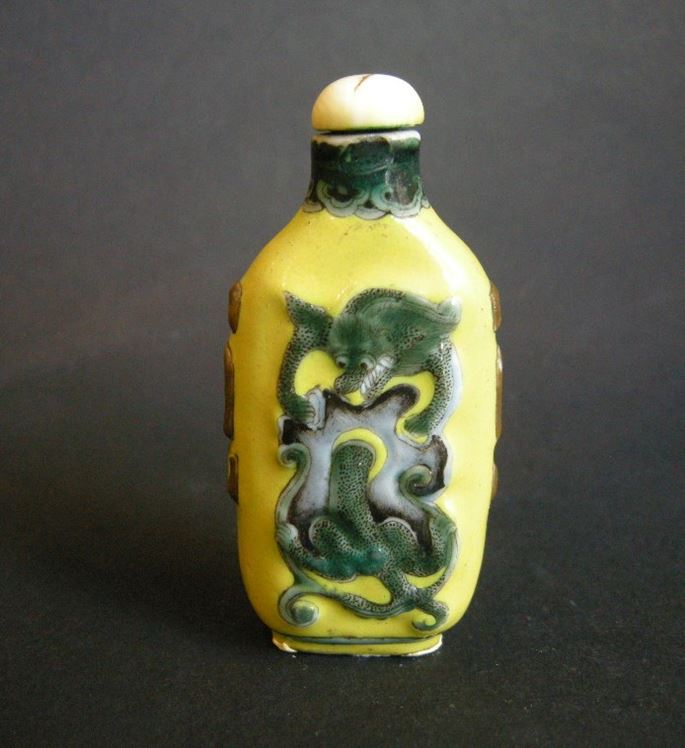 Porcelain snuff bottle influenced by Overlay glass bottle decorated with dragons on yellow ground - Guanxu period | MasterArt